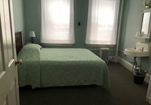 light blue green bed spread on bed at the Coolidge House at Hotel Coolidge